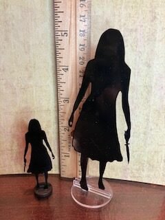 Image both sizes of 2D Shadow Person, Girl with a knife posed next to a ruler to show size