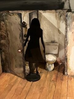 Image of half-scale 2-dimentional shadow girl holding a knife